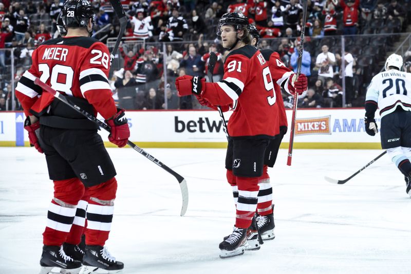 Feb 12, 2024; Newark, New Jersey, USA; New Jersey Devils center Dawson Mercer (91) celebrates with teammates after scoring a goal against the Seattle Kraken during the second period at Prudential Center. Mandatory Credit: John Jones-USA TODAY Sports