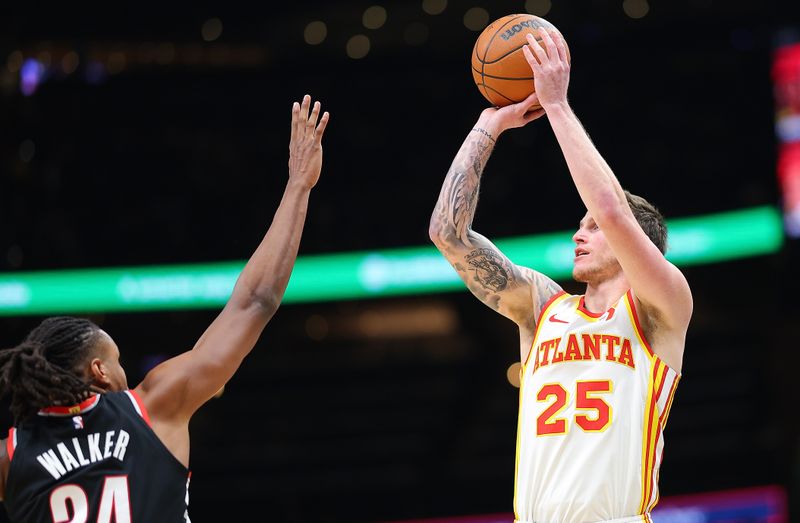 ATLANTA, GEORGIA - MARCH 27:  Garrison Mathews #25 of the Atlanta Hawks draws a foul as he hits this three-point basket against Jabari Walker #34 of the Portland Trail Blazers during the third quarter at State Farm Arena on March 27, 2024 in Atlanta, Georgia.  NOTE TO USER: User expressly acknowledges and agrees that, by downloading and/or using this photograph, user is consenting to the terms and conditions of the Getty Images License Agreement.  (Photo by Kevin C. Cox/Getty Images)