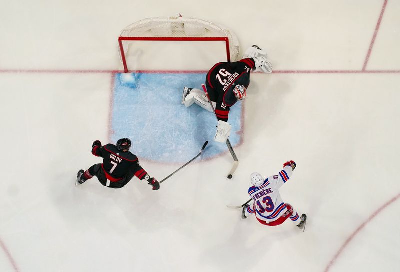 Mar 12, 2024; Raleigh, North Carolina, USA; Carolina Hurricanes goaltender Pyotr Kochetkov (52) pokes the puck  away from New York Rangers left wing Alexis Lafreniere (13) during the third period at PNC Arena. Mandatory Credit: James Guillory-USA TODAY Sports