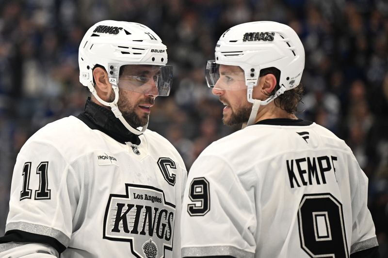 Nov 13, 2025; Toronto, Ontario, CAN;  Los Angeles Kings forwards Anze Kopitar (11) and Adrian Kempe (9) talk before a faceoff against the Toronto Maple Leafs in the third period at Scotiabank Arena. Mandatory Credit: Dan Hamilton-Imagn Images
