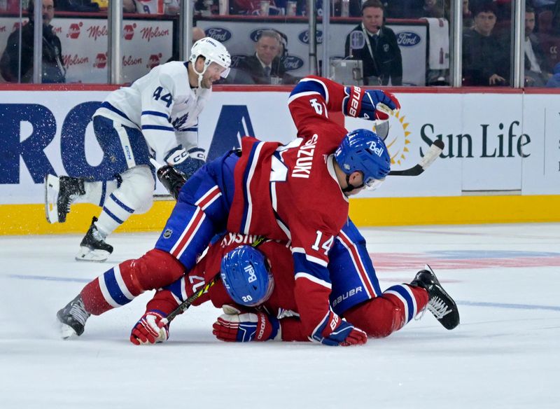 Oct 9, 2024; Montreal, Quebec, CAN; Montreal Canadiens forward Juraj Slafkovsky (20) and teammate forward Nick Suzuki (14) collide during the third period of the game against the Toronto Maple Leafs at the Bell Centre. Mandatory Credit: Eric Bolte-Imagn Images