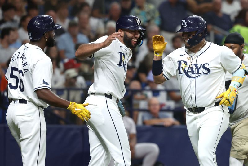 Jul 9, 2024; St. Petersburg, Florida, USA;  Tampa Bay Rays third base Isaac Paredes (17) is congratulated by outfielder Amed Rosario (10),and outfielder Randy Arozarena (56) after he hit a three run home run against the New York Yankees during the first inning at Tropicana Field. Mandatory Credit: Kim Klement Neitzel-USA TODAY Sports