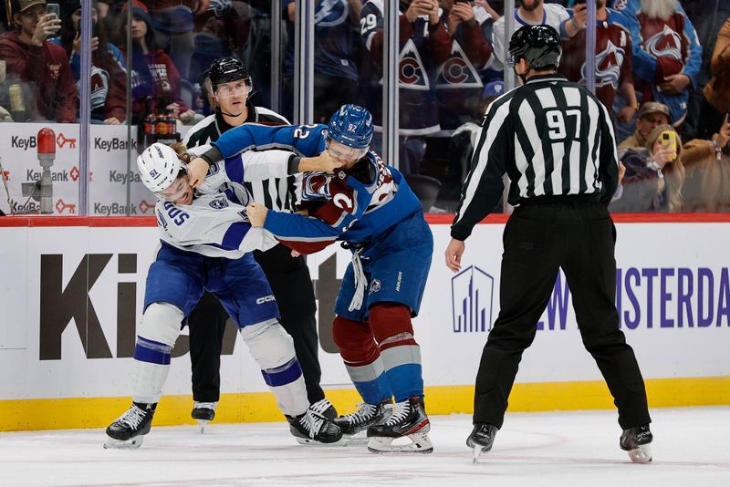 Nov 4, 2025; Denver, Colorado, USA; Tampa Bay Lightning defenseman Charle-Edouard D'Astous (51) an dColorado Avalanche left wing Gabriel Landeskog (92) fight as linesman Jeremy Faucher (97) looks on in the first period at Ball Arena. Mandatory Credit: Isaiah J. Downing-Imagn Images