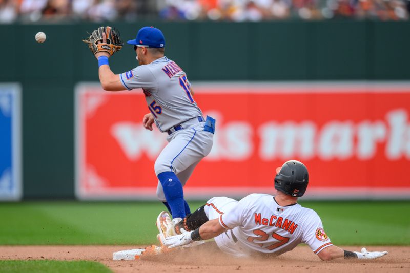 Aug 6, 2023; Baltimore, Maryland, USA; Baltimore Orioles catcher James McCann (27) reaches second base safely before the tag by New York Mets shortstop Danny Mendick (15) during the seventh inning at Oriole Park at Camden Yards. Mandatory Credit: Reggie Hildred-USA TODAY Sports