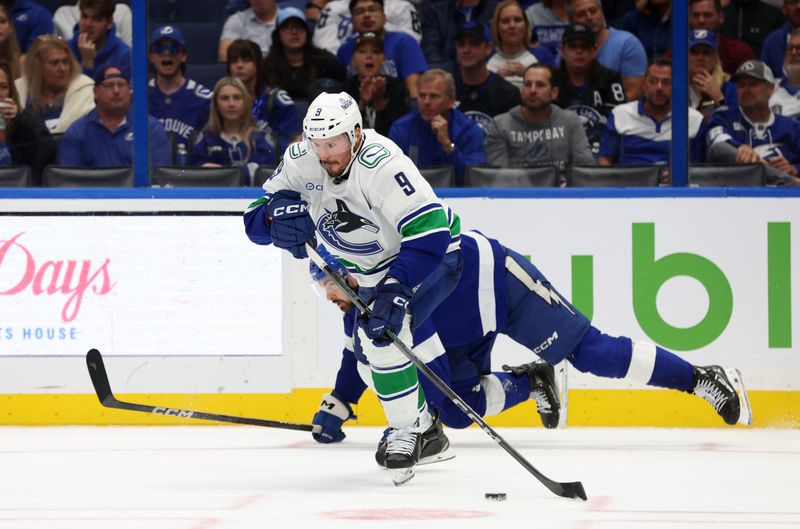 Oct 15, 2024; Tampa, Florida, USA; Vancouver Canucks center J.T. Miller (9) skates with the puck against the Tampa Bay Lightning during the third period at Amalie Arena. Mandatory Credit: Kim Klement Neitzel-Imagn Images