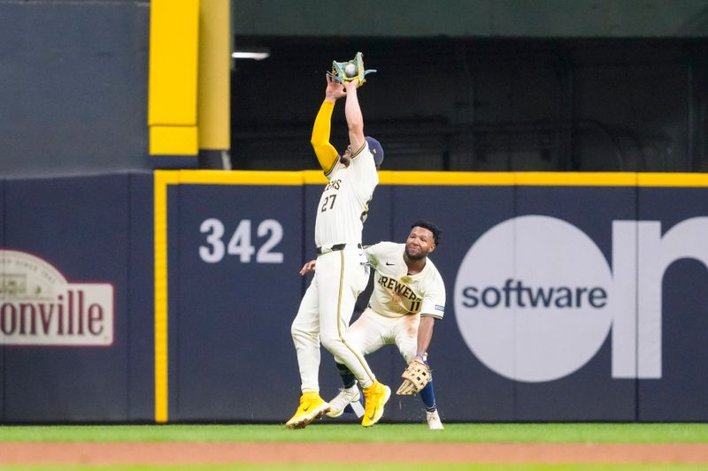 Aug 27, 2024; Milwaukee, Wisconsin, USA;  Milwaukee Brewers shortstop Willy Adames (27) catches a fly ball in front of left fielder Jackson Chourio during the fifth inning against the Milwaukee Brewers at American Family Field. Mandatory Credit: Jeff Hanisch-USA TODAY Sports