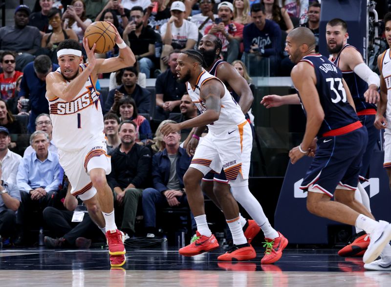 INGLEWOOD, CALIFORNIA - OCTOBER 23: Devin Booker #1 of the Phoenix Suns grabs a rebound in front of Nicolas Batum #33 of the LA Clippers and Monte Morris #23 during a 116-113 Suns overtime win in the season home opening game at Intuit Dome on October 23, 2024 in Inglewood, California. (Photo by Harry How/Getty Images) NOTE TO USER: User expressly acknowledges and agrees that, by downloading and or using this photograph, User is consenting to the terms and conditions of the Getty Images License Agreement. (Photo by Harry How/Getty Images)