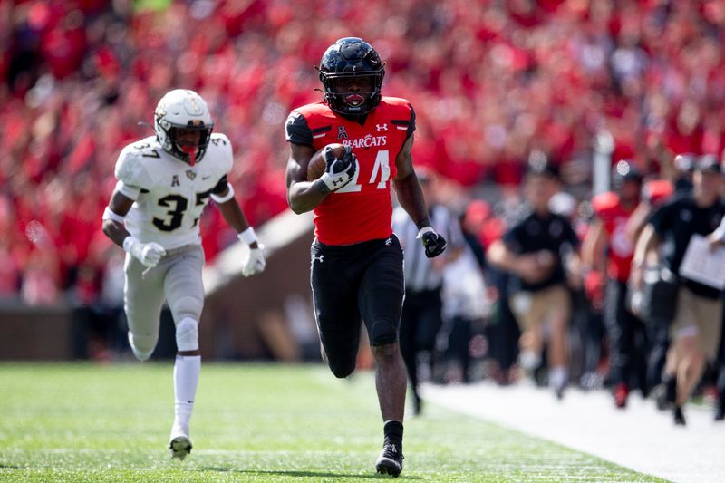 Oct 16, 2021; Cincinnati, Ohio, USA; Cincinnati Bearcats running back Jerome Ford (24) runs for a 79-yard touchdown as UCF Knights defensive back Quadric Bullard (37) chases in the first half of the NCAA football game between the Cincinnati Bearcats and the UCF Knights at Nippert Stadium. Mandatory Credit: Albert Cesare / The Enquirer-USA TODAY Sports