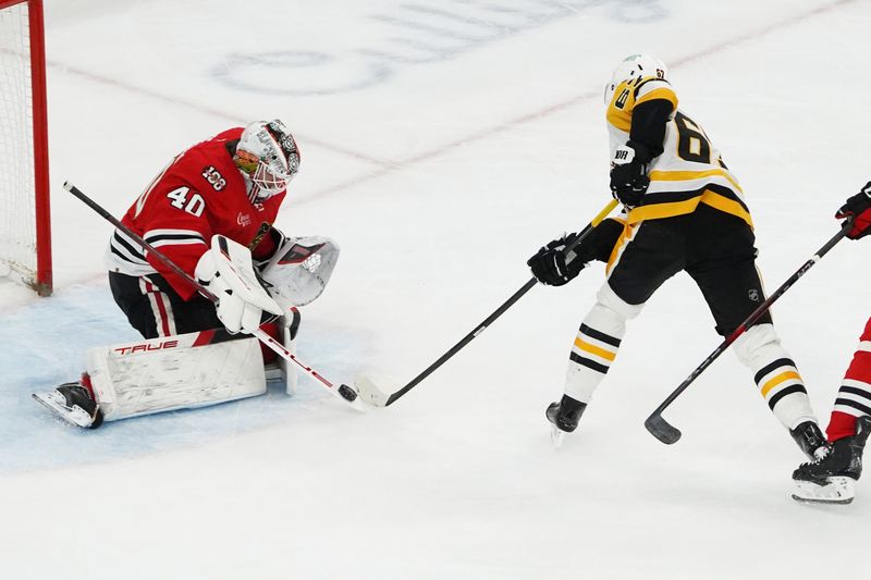 Dec 28, 2025; Chicago, Illinois, USA; Chicago Blackhawks goaltender Arvid Soderblom (40) makes a save on Pittsburgh Penguins right wing Rickard Rakell (67) during the second period at United Center. Mandatory Credit: David Banks-Imagn Images