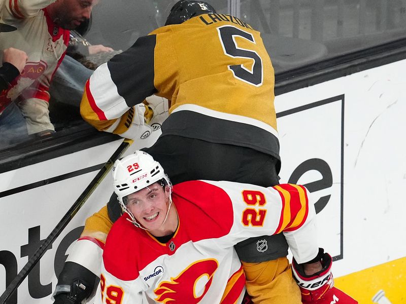 Oct 18, 2025; Las Vegas, Nevada, USA; Calgary Flames left wing Samuel Honzek (29) looks towards a referee while holding Vegas Golden Knights defenseman Jeremy Lauzon (5) during the third period at T-Mobile Arena. Mandatory Credit: Stephen R. Sylvanie-Imagn Images