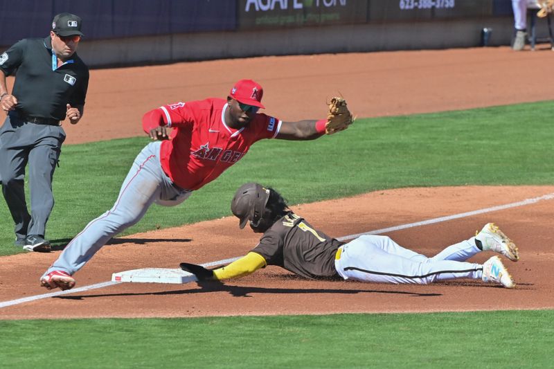 Mar 1, 2024; Peoria, Arizona, USA; San Diego Padres shortstop Ha-Seong Kim (7) steals third base as Los Angeles Angels third baseman Miguel Sano (22) misses the catch in the second inning during a spring training game at Peoria Sports Complex. Mandatory Credit: Matt Kartozian-USA TODAY Sports