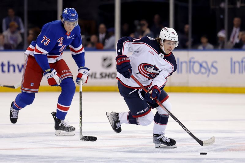 Feb 28, 2024; New York, New York, USA; Columbus Blue Jackets center Kent Johnson (91) skates with the puck against New York Rangers center Matt Rempe (73) during the first period at Madison Square Garden. Mandatory Credit: Brad Penner-USA TODAY Sports