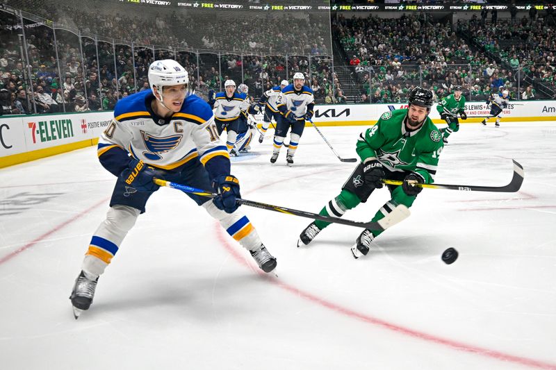 Dec 14, 2024; Dallas, Texas, USA; St. Louis Blues center Brayden Schenn (10) clears the puck in front of Dallas Stars left wing Jamie Benn (14) during the second period at American Airlines Center. Mandatory Credit: Jerome Miron-Imagn Images