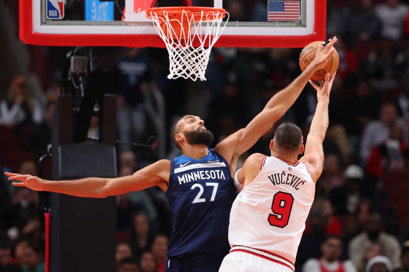 CHICAGO, ILLINOIS - OCTOBER 16: Rudy Gobert #27 of the Minnesota Timberwolves defends a shot by Nikola Vucevic #9 of the Chicago Bulls during the second half of a preseason game at the United Center on October 16, 2024 in Chicago, Illinois. NOTE TO USER: User expressly acknowledges and agrees that, by downloading and or using this photograph, User is consenting to the terms and conditions of the Getty Images License Agreement.  (Photo by Michael Reaves/Getty Images)