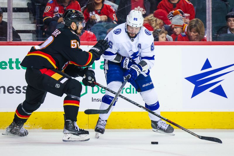 Jan 21, 2023; Calgary, Alberta, CAN; Tampa Bay Lightning right wing Nikita Kucherov (86) and Calgary Flames defenseman MacKenzie Weegar (52) battle for the puck during the first period at Scotiabank Saddledome. Mandatory Credit: Sergei Belski-USA TODAY Sports