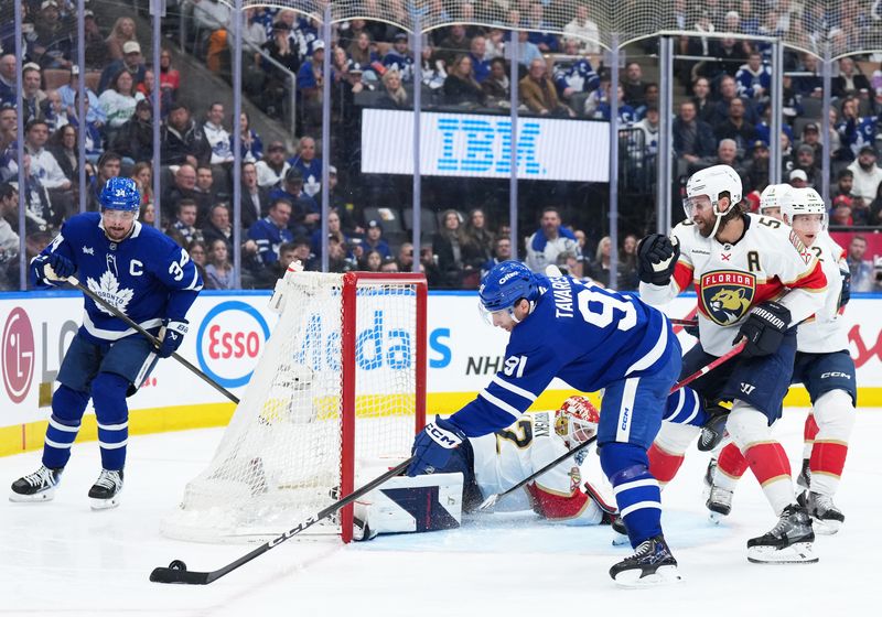 Jan 6, 2026; Toronto, Ontario, CAN; Toronto Maple Leafs center John Tavares (91) battles for the puck in front of the net with Florida Panthers defenseman Aaron Ekblad (5) during the third period at Scotiabank Arena. Mandatory Credit: Nick Turchiaro-Imagn Images