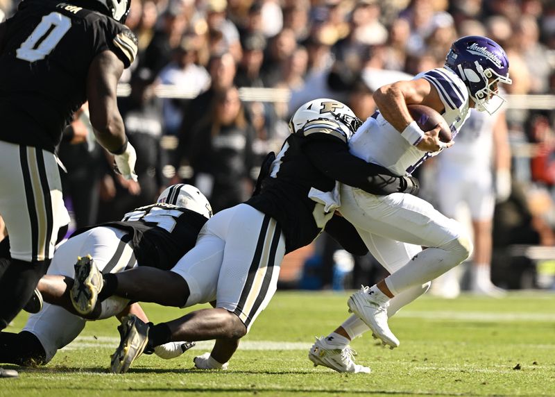 Nov 2, 2024; West Lafayette, Indiana, USA; Northwestern Wildcats quarterback Jack Lausch (12) is sacked by Purdue Boilermakers defensive end Jireh Ojata (99) during the second half at Ross-Ade Stadium. Mandatory Credit: Marc Lebryk-Imagn Images