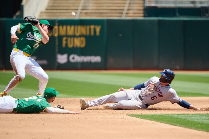 May 26, 2024; Oakland, California, USA; Oakland Athletics infielder Max Schuemann (12) commits a throwing error to infielder Zack Gelof (20) as Houston Astros outfielder Jake Meyers (6) slides into second base during the fourth inning at Oakland-Alameda County Coliseum. Mandatory Credit: Robert Edwards-USA TODAY Sports