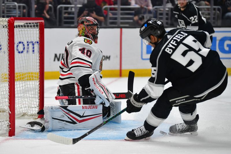 Apr 18, 2024; Los Angeles, California, USA;Chicago Blackhawks goaltender Arvid Soderblom (40) blocks a shot against Los Angeles Kings right wing Quinton Byfield (55)  during the second period at Crypto.com Arena. Mandatory Credit: Gary A. Vasquez-USA TODAY Sports