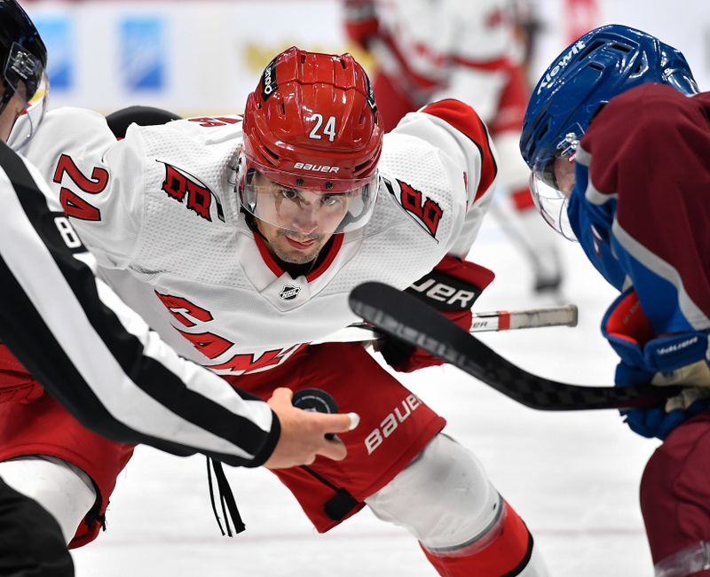 Oct 21, 2023; Denver, Colorado, USA; Carolina Hurricanes center Seth Jarvis (24) keeps his eye on the puck during a face off with Colorado Avalanche center Fredrik Olofsson (22) during the third period at Ball Arena. Mandatory Credit: John Leyba-USA TODAY Sports