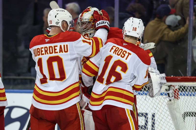 Mar 18, 2025; New York, New York, USA;  Calgary Flames goaltender Dan Vladar (80) celebrates with left wing Jonathan Huberdeau (10) and center Morgan Frost (16) after defeating the New York Rangers 2-1 at Madison Square Garden. Mandatory Credit: Wendell Cruz-Imagn Images