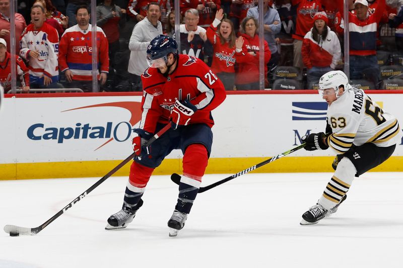 Apr 15, 2024; Washington, District of Columbia, USA; Washington Capitals center Nic Dowd (26) scores an empty net goal as Boston Bruins left wing Brad Marchand (63) defends in the final minute of the third period at Capital One Arena. Mandatory Credit: Geoff Burke-USA TODAY Sports