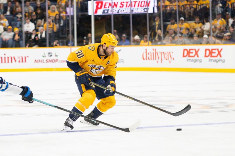 Nov 23, 2024; Nashville, Tennessee, USA; Nashville Predators center Ryan O'Reilly (90) skates with the puck against against the Winnipeg Jets during the second period at Bridgestone Arena. Mandatory Credit: Steve Roberts-Imagn Images