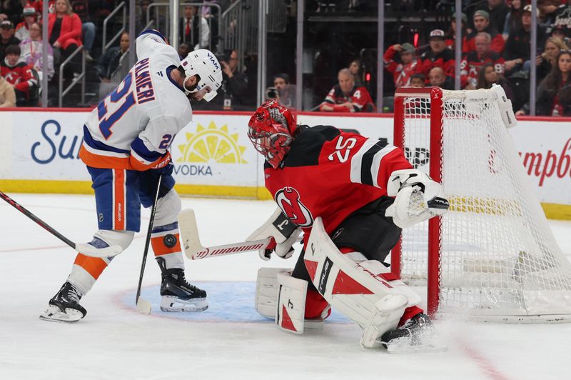 Nov 10, 2025; Newark, New Jersey, USA; New Jersey Devils goaltender Jacob Markstrom (25) makes a save on New York Islanders center Kyle Palmieri (21) during the third period at Prudential Center. Mandatory Credit: Ed Mulholland-Imagn Images