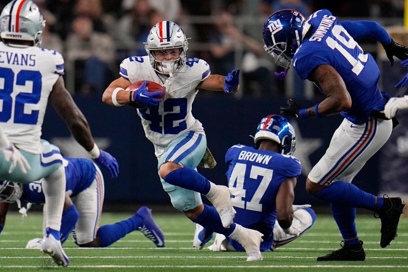 Dallas Cowboys running back Deuce Vaughn (42) carries against New York Giants safety Isaiah Simmons (19) in the first half of an NFL football game, Sunday, Nov. 12, 2023, in Arlington, Texas. (AP Photo/Julio Cortez)