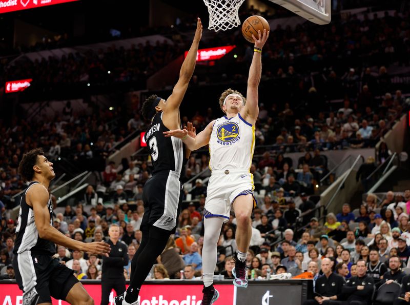 SAN ANTONIO, TX - MARCH 11:  Brandin Podziemski #2 of the Golden State Warriors drives past Keldon Johnson #3 of the San Antonio Spurs in the second half at Frost Bank Center on March 11, 2024 in San Antonio, Texas. NOTE TO USER: User expressly acknowledges and agrees that, by downloading and or using this photograph, User is consenting to terms and conditions of the Getty Images License Agreement. (Photo by Ronald Cortes/Getty Images)