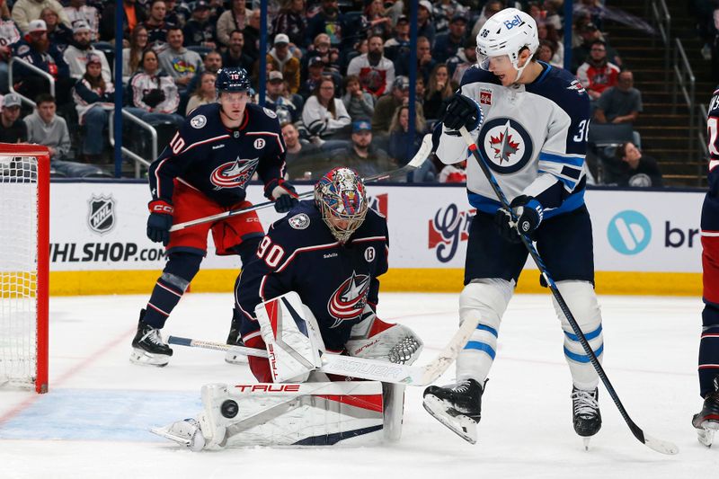 Nov 1, 2024; Columbus, Ohio, USA; Columbus Blue Jackets goalie Elvis Merzlikins (90) makes a and save as Winnipeg Jets center Morgan Barron (36) looks for the rebound during the third period at Nationwide Arena. Mandatory Credit: Russell LaBounty-Imagn Images