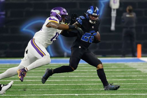 Detroit Lions running back Jahmyr Gibbs (26) is tackled by Minnesota Vikings linebacker Dallas Turner (15) in the first half of an NFL football game in Detroit, Sunday, Jan. 5, 2025. (AP Photo/Rick Osentoski)