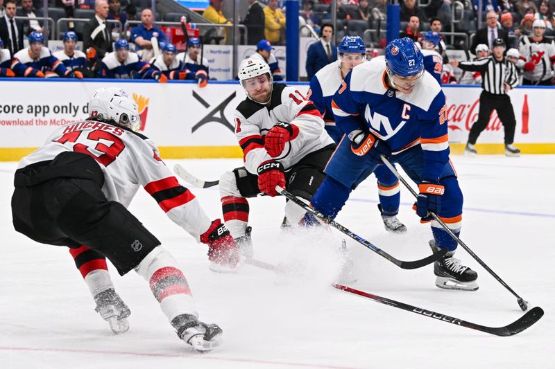 Mar 24, 2024; Elmont, New York, USA;  New Jersey Devils center Chris Tierney (11) defends against New York Islanders left wing Anders Lee (27) during the second period at UBS Arena. Mandatory Credit: Dennis Schneidler-USA TODAY Sports