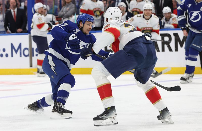 Apr 30, 2025; Tampa, Florida, USA; Tampa Bay Lightning center Yanni Gourde (37) shoots as Florida Panthers center Eetu Luostarinen (27) defends during the first period of game five of the first round of the 2025 Stanley Cup Playoffs at Amalie Arena. Mandatory Credit: Kim Klement Neitzel-Imagn Images