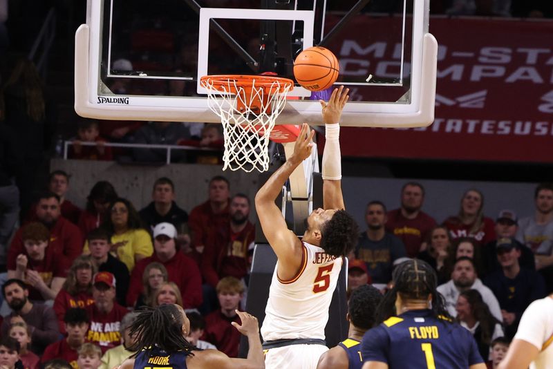 Jan 2, 2026; Ames, Iowa, USA; Iowa State Cyclones forward Joshua Jefferson (5) shoots and scores in front of West Virginia Mountaineers guard Jasper Floyd (1) during the second half at James H. Hilton Coliseum. Mandatory Credit: Reese Strickland-Imagn Images
