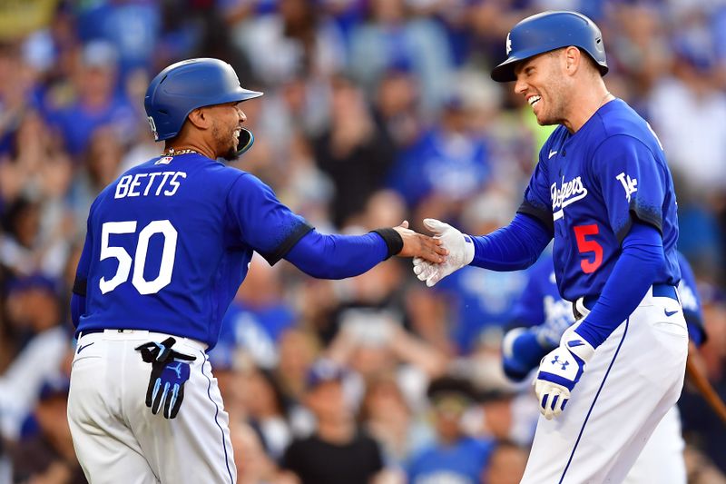 Jul 6, 2023; Los Angeles, California, USA; Los Angeles Dodgers first baseman Freddie Freeman (5) is greeted by second baseman Mookie Betts (50) after hitting a two run home run against the Pittsburgh Pirates during the first inning at Dodger Stadium. Mandatory Credit: Gary A. Vasquez-USA TODAY Sports