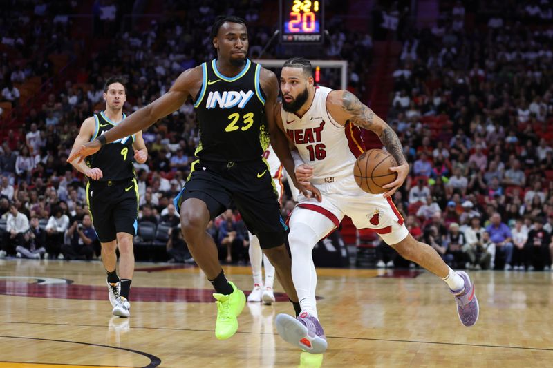 MIAMI, FLORIDA - DECEMBER 02: Caleb Martin #16 of the Miami Heat drives against Aaron Nesmith #23 of the Indiana Pacers during the first quarter of the game at Kaseya Center on December 02, 2023 in Miami, Florida. NOTE TO USER: User expressly acknowledges and agrees that, by downloading and or using this photograph, User is consenting to the terms and conditions of the Getty Images License Agreement. (Photo by Megan Briggs/Getty Images)