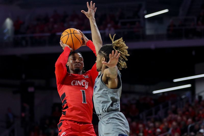 Mar 9, 2024; Cincinnati, Ohio, USA; Cincinnati Bearcats guard Day Day Thomas (1) shoots against West Virginia Mountaineers guard Noah Farrakhan (1) in the first half at Fifth Third Arena. Mandatory Credit: Katie Stratman-USA TODAY Sports