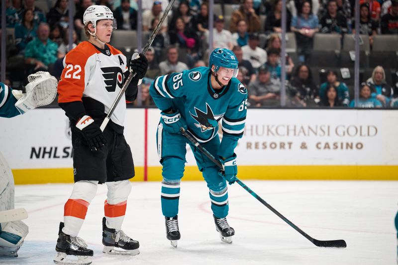 Mar 21, 2026; San Jose, California, USA; San Jose Sharks defender Shakir Mukhamadullin (85) reacts after blocking a shot and Philadelphia Flyers center Christian Dvorak (22) looks on during the first period at SAP Center at San Jose. Mandatory Credit: Robert Edwards-Imagn Images