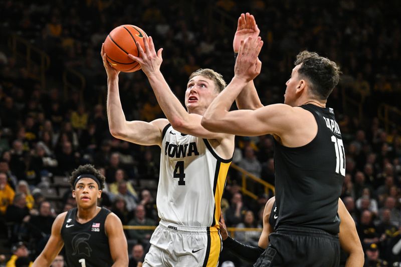 Mar 6, 2025; Iowa City, Iowa, USA; Iowa Hawkeyes guard Josh Dix (4) goes to the basket as Michigan State Spartans center Szymon Zapala (10) defends during the second half at Carver-Hawkeye Arena. Mandatory Credit: Jeffrey Becker-Imagn Images