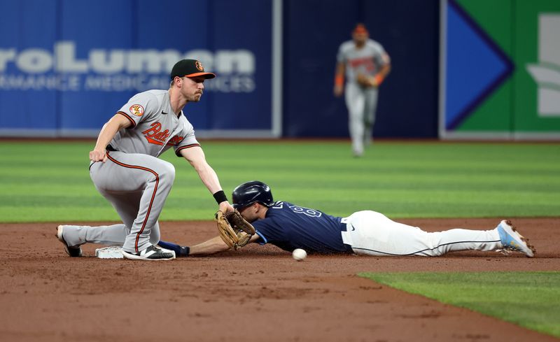 Jun 10, 2024; St. Petersburg, Florida, USA; Tampa Bay Rays second base Brandon Lowe (8) slides safe into second base as Baltimore Orioles third base Jordan Westburg (11) attempted to tag him out during the first inning at Tropicana Field. Mandatory Credit: Kim Klement Neitzel-USA TODAY Sports