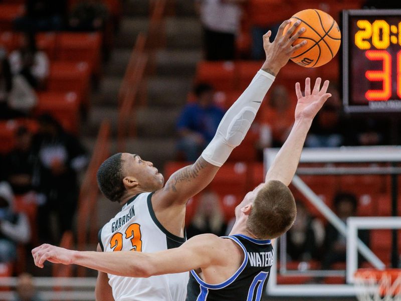 Feb 17, 2024; Stillwater, Oklahoma, USA; Oklahoma State Cowboys center Brandon Garrison (23) gets the tip over Brigham Young Cougars forward Noah Waterman (0) to start the game at Gallagher-Iba Arena. Mandatory Credit: William Purnell-USA TODAY Sports