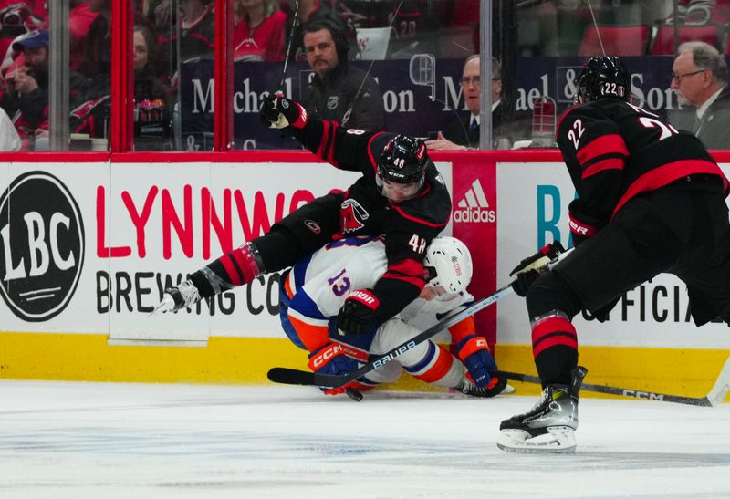 Apr 20, 2024; Raleigh, North Carolina, USA; Carolina Hurricanes left wing Jordan Martinook (48) checks New York Islanders center Mathew Barzal (13) during the second period in game one of the first round of the 2024 Stanley Cup Playoffs at PNC Arena. Mandatory Credit: James Guillory-USA TODAY Sports