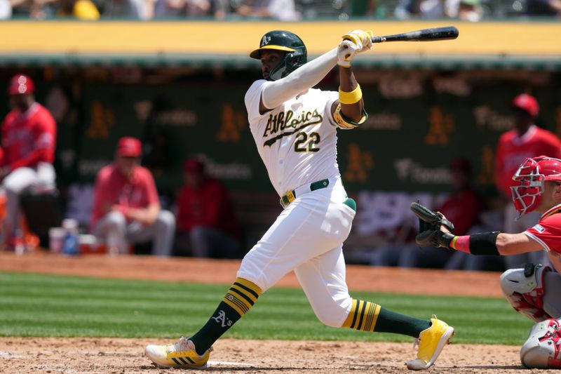 Jul 21, 2024; Oakland, California, USA; Oakland Athletics left fielder Miguel Andujar (22) hits a home run against the Los Angeles Angels during the fifth inning at Oakland-Alameda County Coliseum. Mandatory Credit: Darren Yamashita-USA TODAY Sports