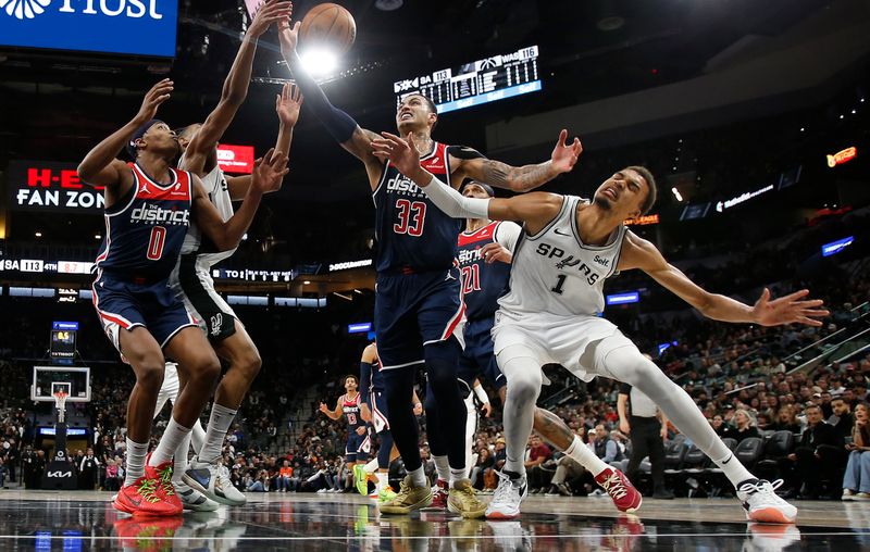 SAN ANTONIO, TX - JANUARY  29:  Kyle Kuzma #33 of the Washington Wizards battles Victor Wembanyama #1 of the San Antonio Spurs for a loose ball  in the second half at Frost Bank Center on January 29, 2024 in San Antonio, Texas. NOTE TO USER: User expressly acknowledges and agrees that, by downloading and or using this photograph, User is consenting to terms and conditions of the Getty Images License Agreement. (Photo by Ronald Cortes/Getty Images)