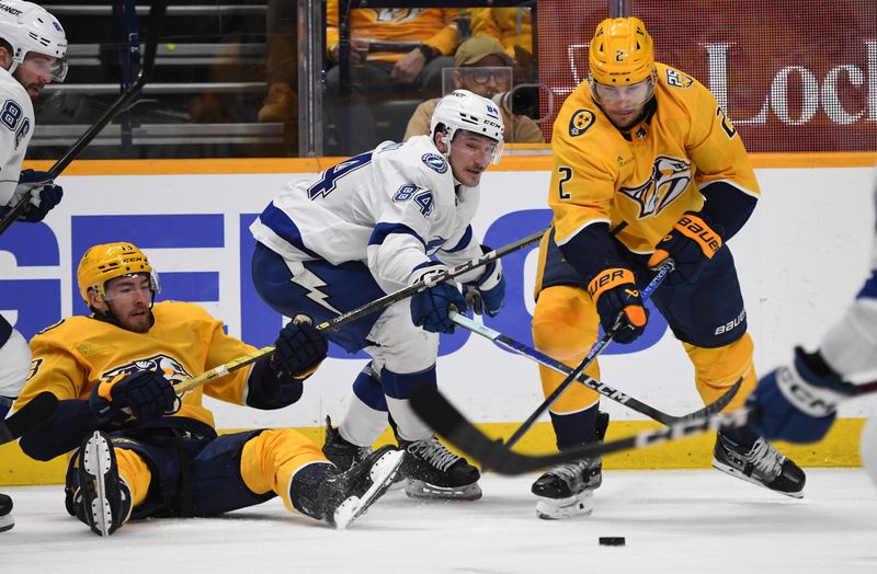 Dec 7, 2023; Nashville, Tennessee, USA; Nashville Predators center Yakov Trenin (13) and defenseman Luke Schenn (2) go for the puck against Tampa Bay Lightning left wing Tanner Jeannot (84) during the second period at Bridgestone Arena. Mandatory Credit: Christopher Hanewinckel-USA TODAY Sports