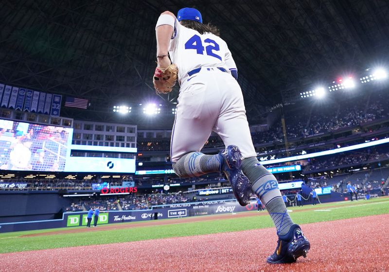 Apr 15, 2024; Toronto, Ontario, CAN; Toronto Blue Jays shortstop Bo Bichette wearing number 42 for Jackie Robinson Day runs onto the field against the New York Yankees during the pregame at Rogers Centre. Mandatory Credit: Nick Turchiaro-USA TODAY Sports