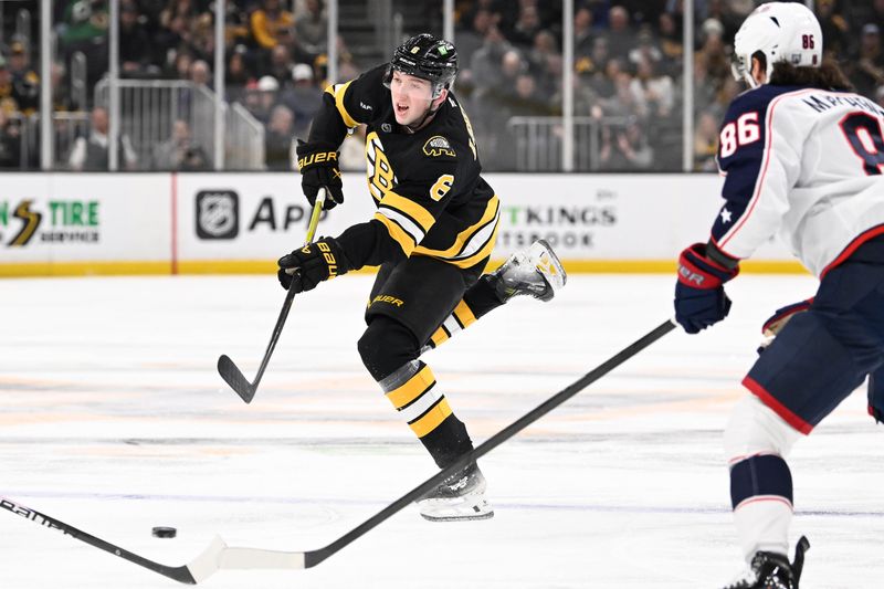 Feb 26, 2026; Boston, Massachusetts, USA; Boston Bruins defenseman Mason Lohrei (6) shoots the puck against Columbus Blue Jackets right wing Kirill Marchenko (86) during the first period at TD Garden. Mandatory Credit: Eric Canha-Imagn Images