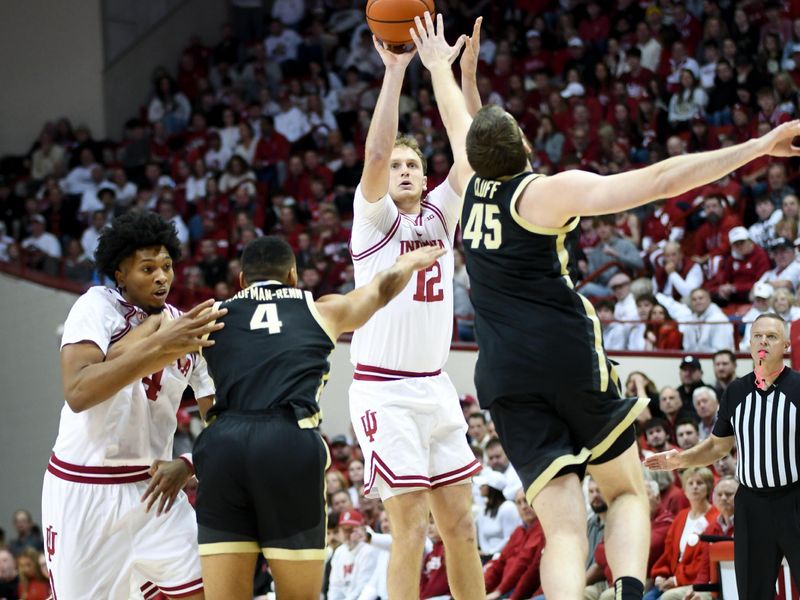 Jan 27, 2026; Bloomington, Indiana, USA; Indiana Hoosiers forward Tucker DeVries (12) shoots the ball over Purdue Boilermakers center Oscar Cluff (45) during the first half at Simon Skjodt Assembly Hall. Mandatory Credit: Robert Goddin-Imagn Images
