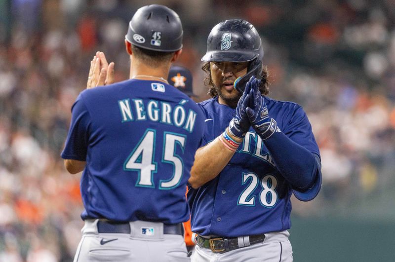 Aug 18, 2023; Houston, Texas, USA;  Seattle Mariners first base coach Kristopher Negr  n (45) celebrates third baseman Eugenio Suarez (28) single against the Houston Astros in the fifth inning at Minute Maid Park. Mandatory Credit: Thomas Shea-USA TODAY Sports